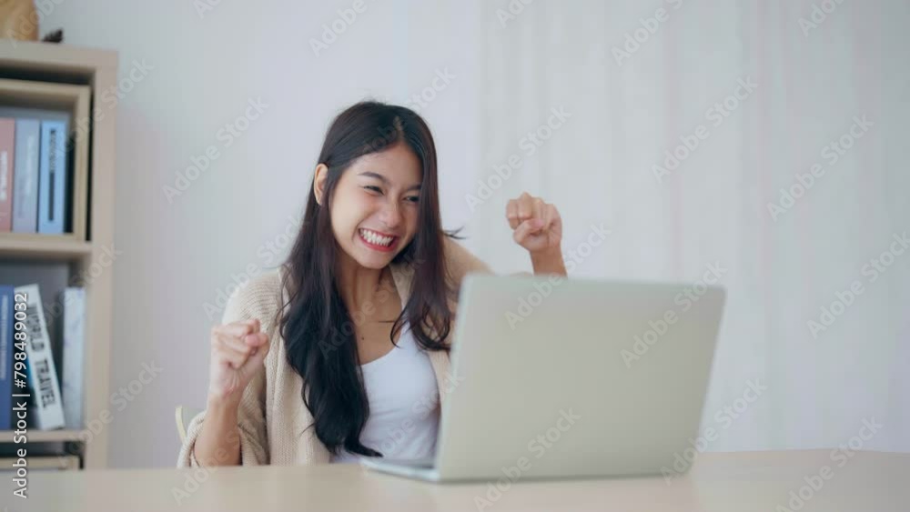 Funny euphoric young asian woman celebrating winning or getting ecommerce shopping offer on computer laptop. Excited happy girl winner looking at notebook celebrating success Funny euphoric young asian woman celebrating winning or getting ecommerce shopping offer on computer laptop. Excited happy girl winner looking at notebook celebrating success
