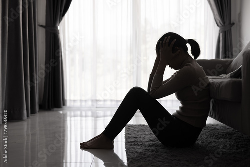 Canvas Print Depressed woman, Silhouette of teenager girl with depression sitting alone  in the dark room