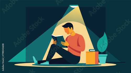 A man sitting under a bright light box with a cup of tea reading a book and soaking up the artificial sunshine..