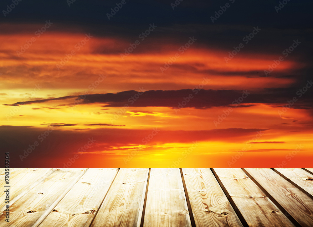 Wooden table on sky background and sunset light
