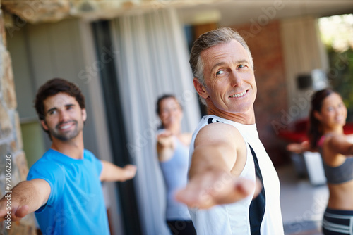 Mature man  pose and happy in yoga class for fitness and mental wellbeing  workout and daily lesson to coach people. Male yogini  warrior posture and yogis or students practice strength and balance.