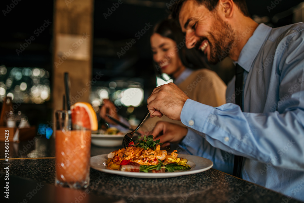 Cheerful couple sitting in a restaurant, having lunch and chatting Cheerful couple sitting in a restaurant, having lunch and chatting