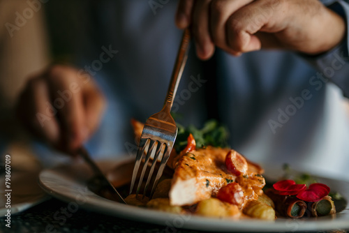 Fotografía Close-up image of people's hands cutting a dish while they having lunch at a res