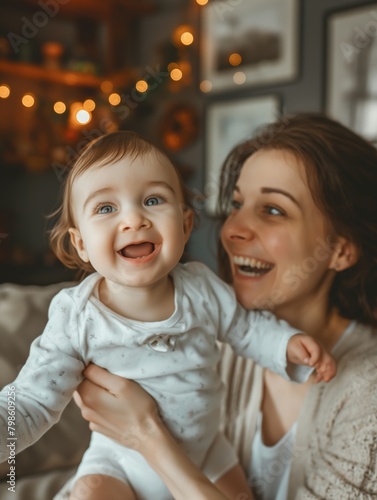 Cheerful mother playing with her child at home trying to catch her toddler close up photo