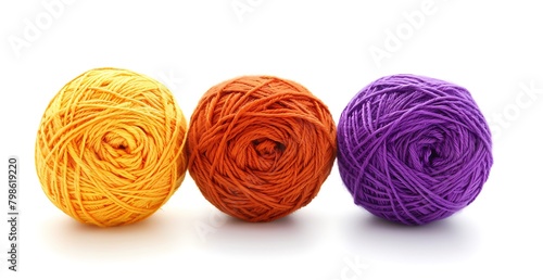 3 yarn balls in orange, purple and yellow colors on a white background