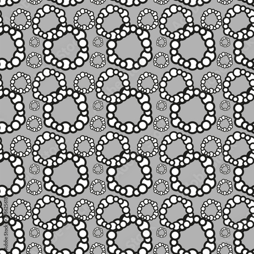 Symmetrical monochrome circles in a seamless pattern on a gray textile backdrop