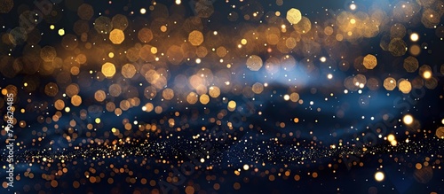 Dark blue and gold particle shine bokeh on navy blue background. Holiday concept background.