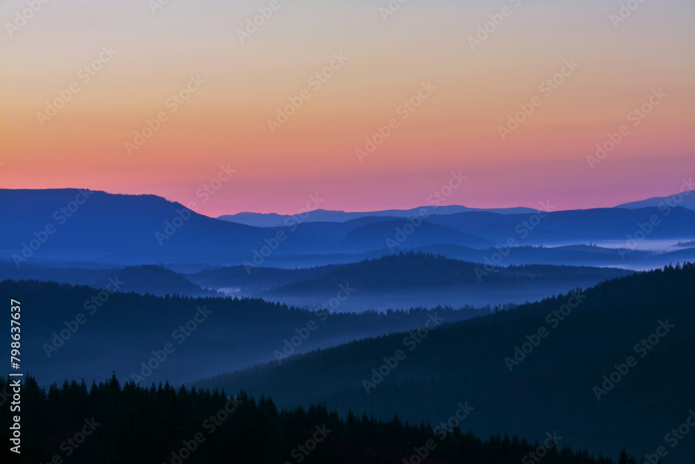 Morning in the mountains. Landscape with fog in the valley between the mountains in the early morning Morning in the mountains. Landscape with fog in the valley between the mountains in the early morning