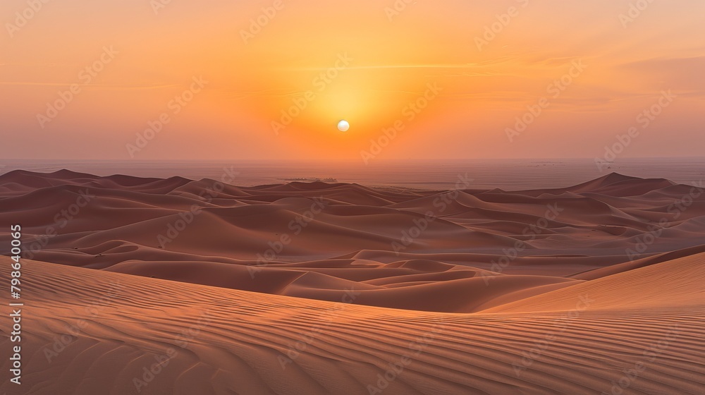 The sun sets over the vast desert sands, casting golden hues across the horizon in Dubai, United Arab Emirates.