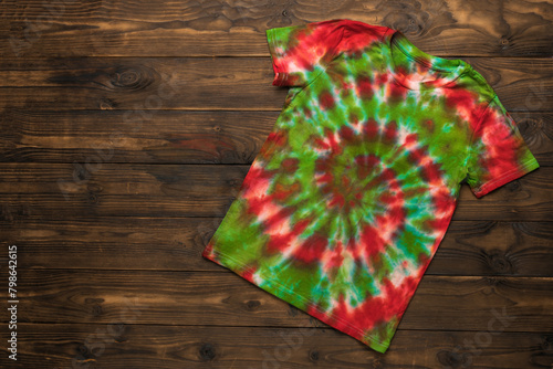 Stylish T-shirt in red and green on a wooden background.