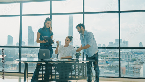 Group of happy skilled businesspeople discuss, brainstorming, sharing idea, plan, strategy about financial statistic on meeting table with laptop and statistic document. Cityscape view. Tracery