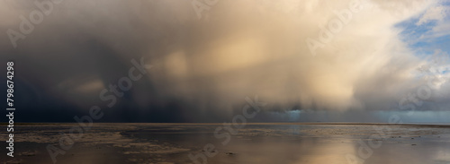 Schilderij op canvas Beautiful moody storm skies over ocean panorama landscape with distant heavy rai
