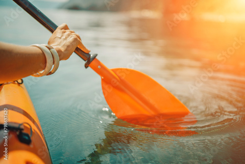 Kayak paddle sea vacation. Person paddles with orange paddle oar on kayak in sea. Leisure active lifestyle recreation activity rest tourism travel photo