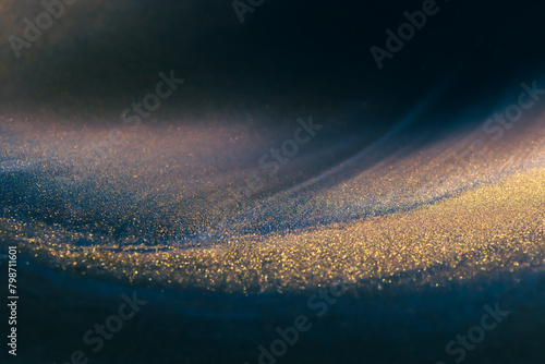 Obraz na płótnie Blue and black acrylic paints with shimmering golden glitter. Liquid paint abstract background. w salonie