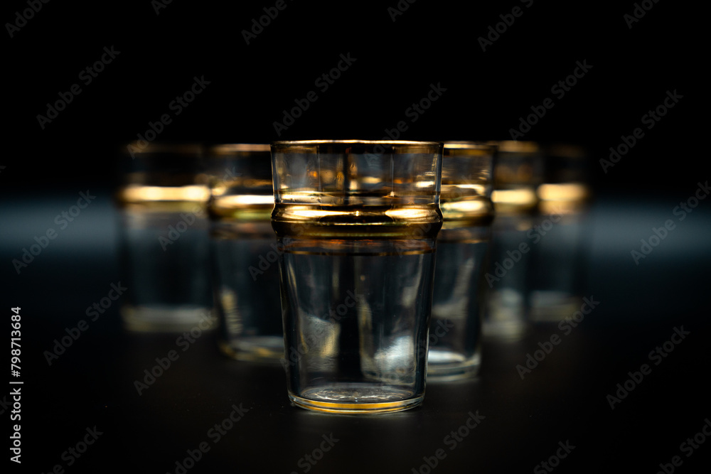 glass of water with gold rings on black close up glass of water with gold rings on black close up