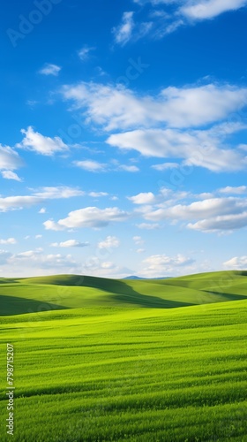 The image shows a beautiful landscape with green hills and a blue sky. The photo was taken on a sunny day and there are some clouds in the sky.