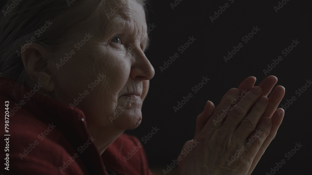shot of old woman sitting near window watching tv shot of old woman sitting near window watching tv