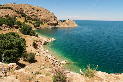 View onto the bay of Akdamar Island on Lake Van, Van Gölü with its little pier, jetty, intense blue, green, turquoise water and seagulls, Van, Turkey
