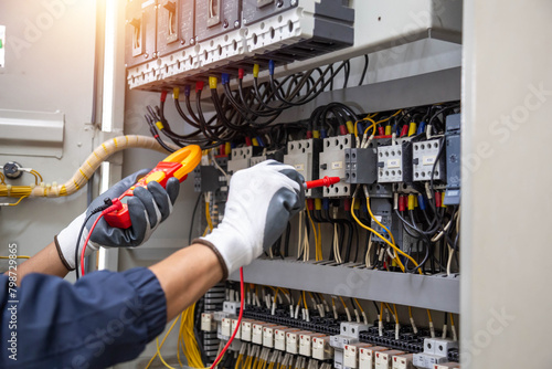 Electricity and electrical maintenance service, Engineer hand holding AC voltmeter checking electric current voltage at circuit breaker terminal and cable .