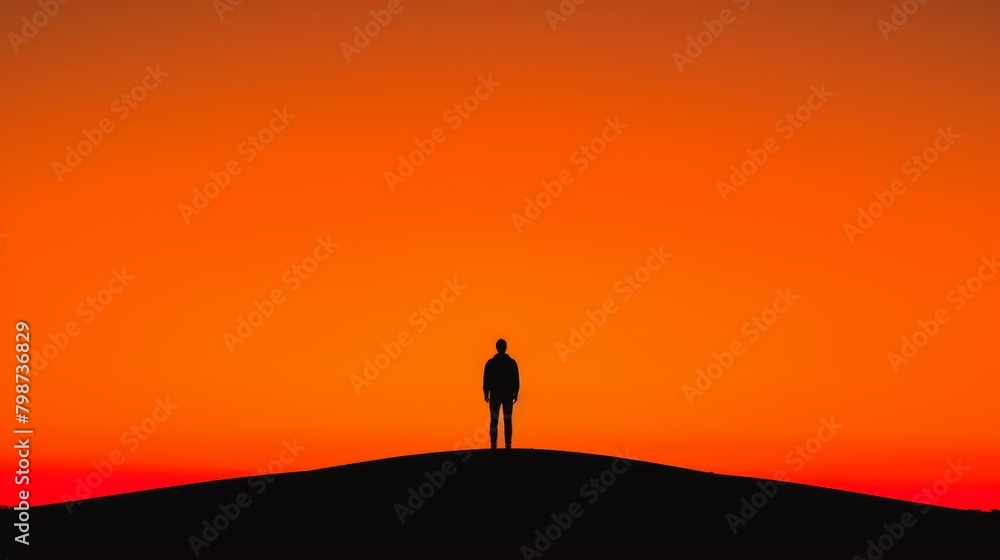 Man's silhouette on hill at sunset, against vibrant orange sky, in minimalistic style