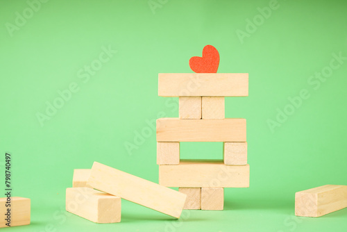 Wooden toy for building a tower from cubes. A heart among wooden cubes
