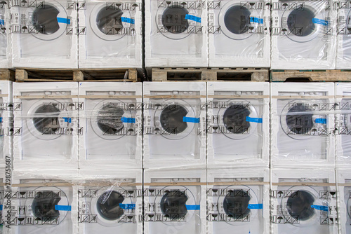 Stacked washing machines in warehouse: Rows of wrapped washing machines in a warehouse
