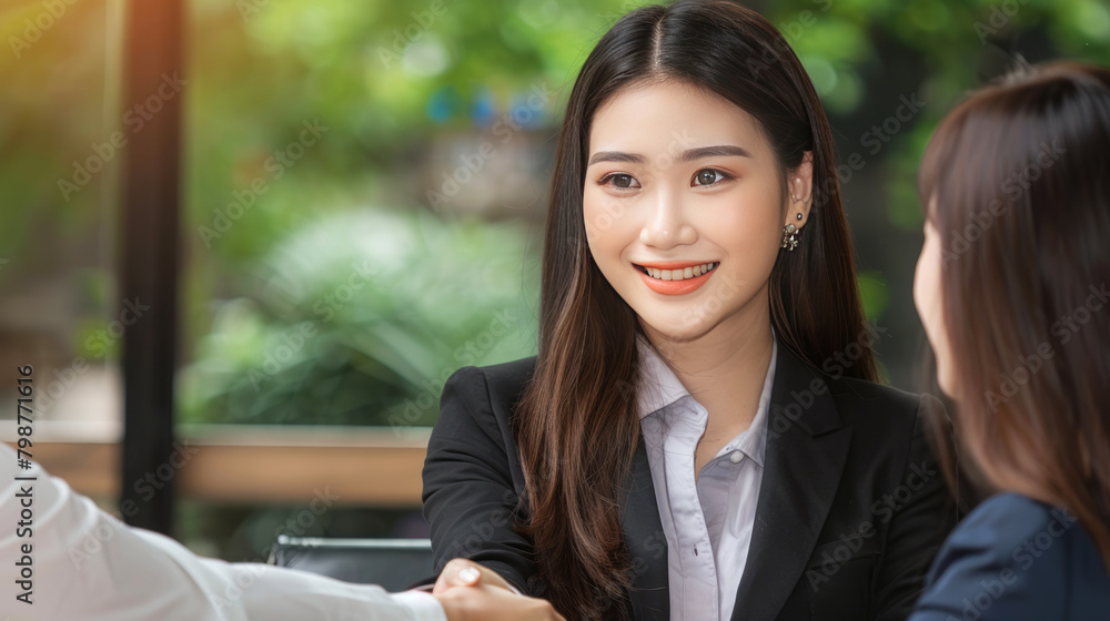 Confident Asian Businesswoman Shaking Hands to Seal a Successful Deal or Partnership Confident Asian Businesswoman Shaking Hands to Seal a Successful Deal or Partnership