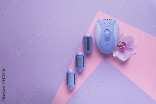 top view of Modern epilator on purple background. skin care, removal of unwanted hair. photo