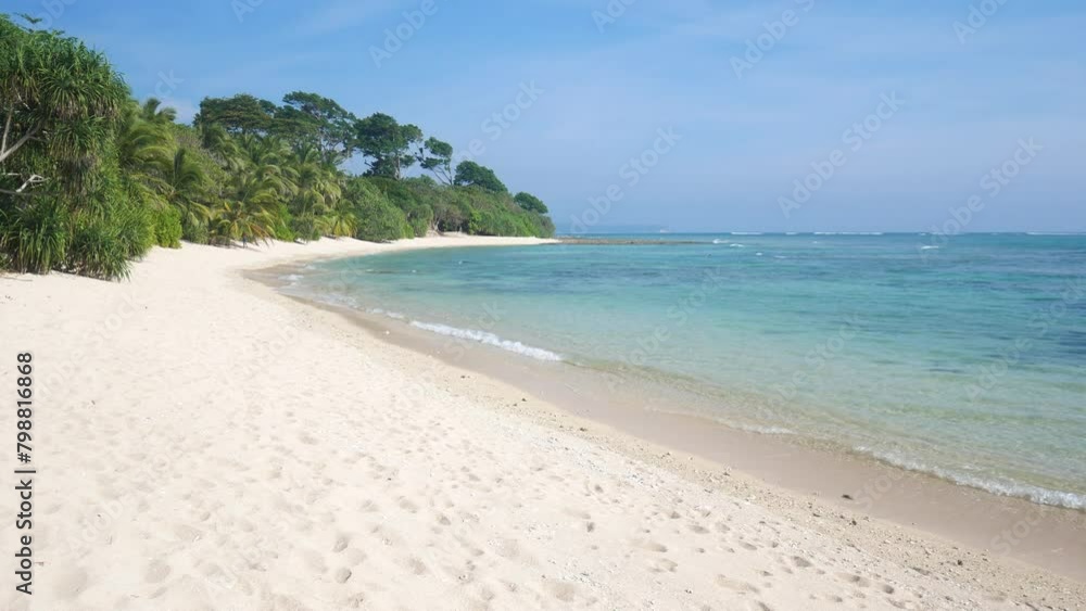 Crystal clear water lapping on tropical beach in the andaman islands. Turquoise water lapping gently on a pristine sandy beach with green jungle in the background Crystal clear water lapping on tropical beach in the andaman islands. Turquoise water lapping gently on a pristine sandy beach with green jungle in the background