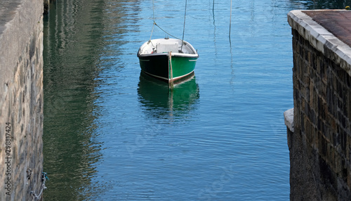 Lone green boat in the calm waters of a harbor