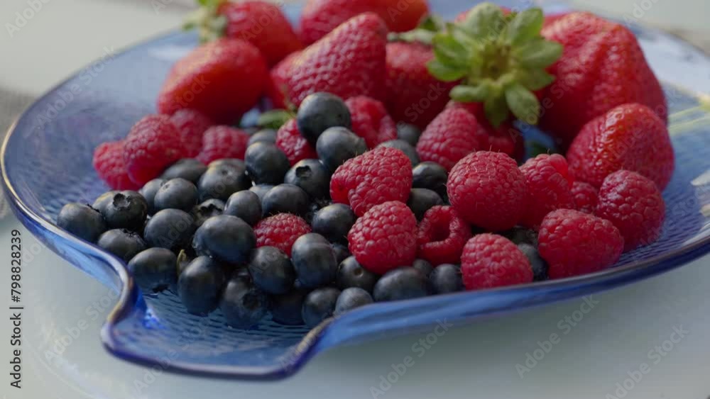 Assortment of Fresh Berries on a Blue Glass Plate for Healthy Snacking Assortment of Fresh Berries on a Blue Glass Plate for Healthy Snacking