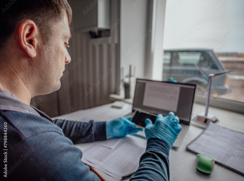 Obraz premium professional in gloves works on a laptop, indicating a rapid and precise analysis in a lab environment