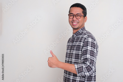 A man smiling at the camera and give thumbs up