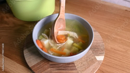 Pour a ladle of soup. Vegetable meal with chiken, hot and cozy soup for dinner at home.
