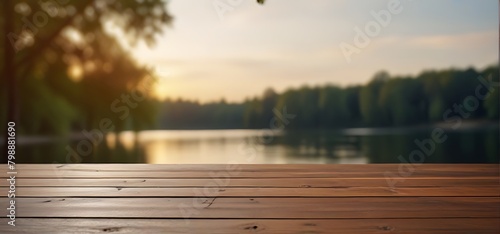 Empty wooden table top with blurred nature background. Calm sunny evening in nature with view to lake, river water and forest, park trees
