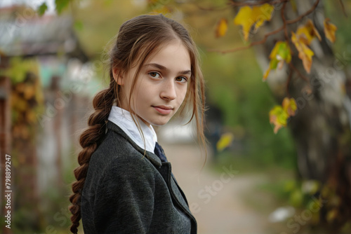 Tranquil and serene outdoor portrait of a young autumn girl with braided hair and a soft smile, enjoying the peacefulness of the fall foliage and natural light in a tranquil autumnal setting