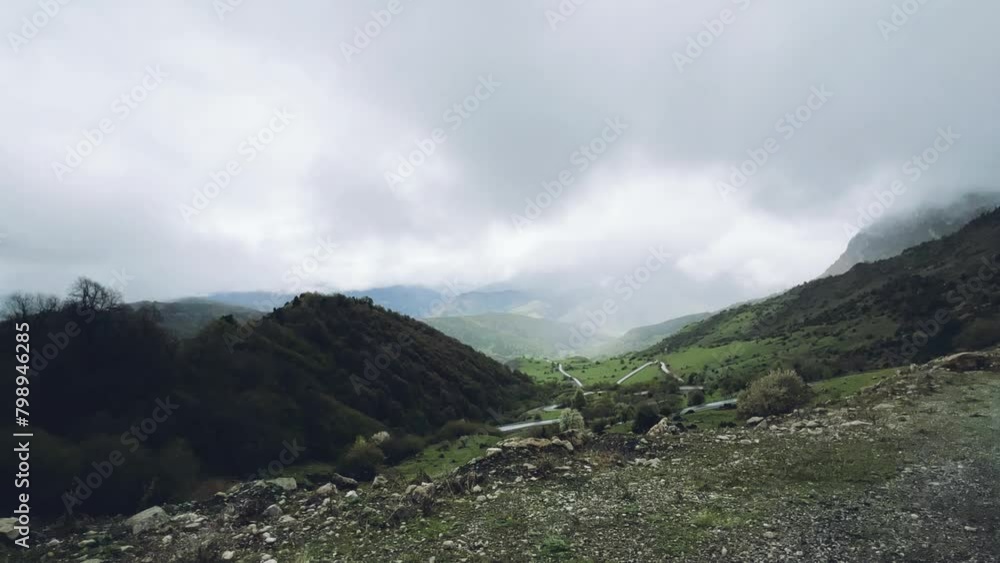 Ceylomsky pass from a car window in Ingushetia. A trip uphill to the Tsei Loam pass on a cloudy spring day. Panorama of the high cliffs of the Dzheyrakh gorge. The Caucasus, the mountains in the fog. Ceylomsky pass from a car window in Ingushetia. A trip uphill to the Tsei Loam pass on a cloudy spring day. Panorama of the high cliffs of the Dzheyrakh gorge. The Caucasus, the mountains in the fog.