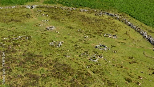 Grimspound prehistoric Late Bronze Age site. Dartmoor, England. From 1300 BC. Hut circles and enclosure wall. Aerial video fly down low. South half photo