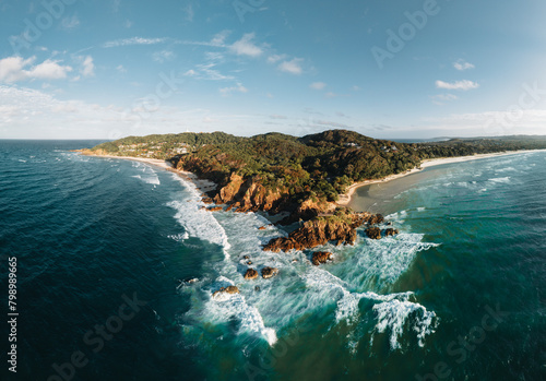 Byron Bay lighthouse and the pass high on the rocky headland - the most eastern point of Australian continent facing Pacific ocean in elevated aerial seascape above coast. photo