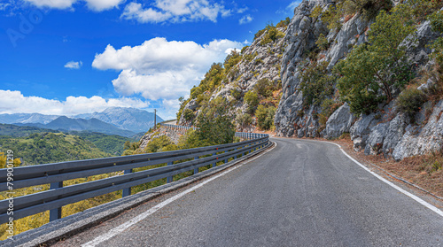 Country road with rocky mountains in the background.