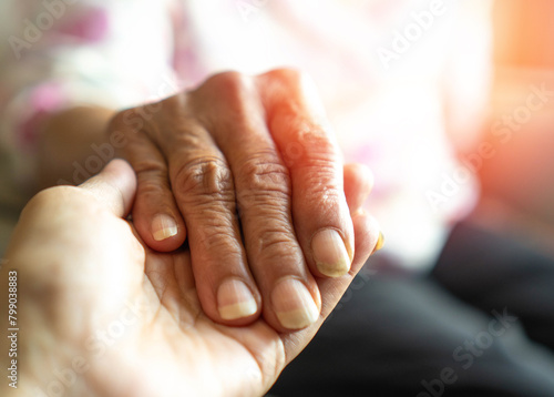Caregiver, carer hand holding elder hand in hospice care background. Philanthropy kindness to disabled old people concept.Happy mother's day.