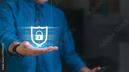 Administrator is holding a phone and a blue shield with a lock on it. Concept of security and protection, hacker, ransomware, malware, victim, attacker, locked