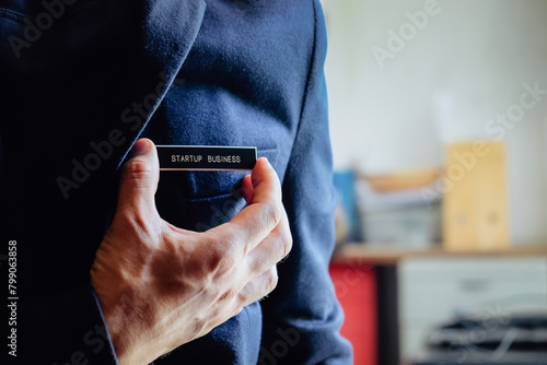 businessman holding a startup business label in his hand, business concept