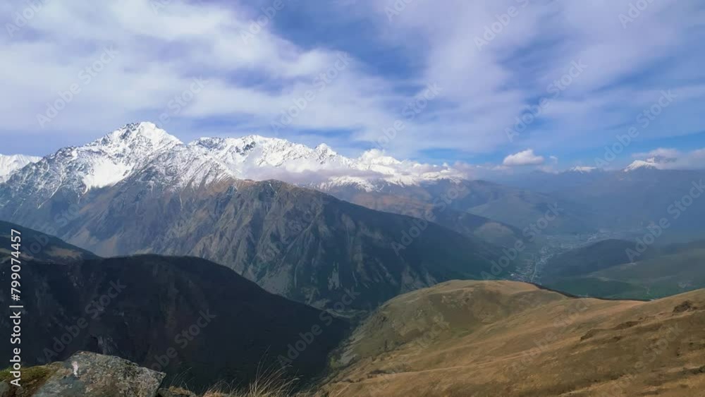 Archonsky Pass. The pass connects the Kurtatinsky gorge with the Alagirsky. Alanya, view of the mountains of the North Caucasus, peaks covered with snow. Sunny day, blue sky with a slight haze. 4К Archonsky Pass. The pass connects the Kurtatinsky gorge with the Alagirsky. Alanya, view of the mountains of the North Caucasus, peaks covered with snow. Sunny day, blue sky with a slight haze. 4К