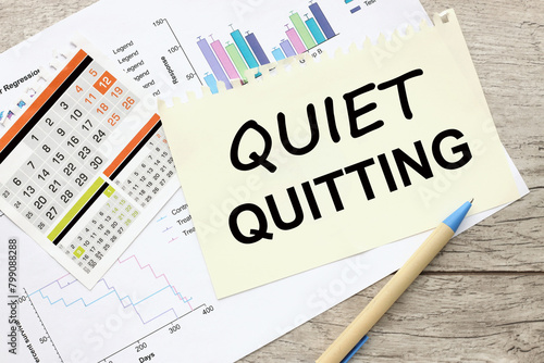 Quiet quitting symbol. sheet of paper with text on financial charts photo