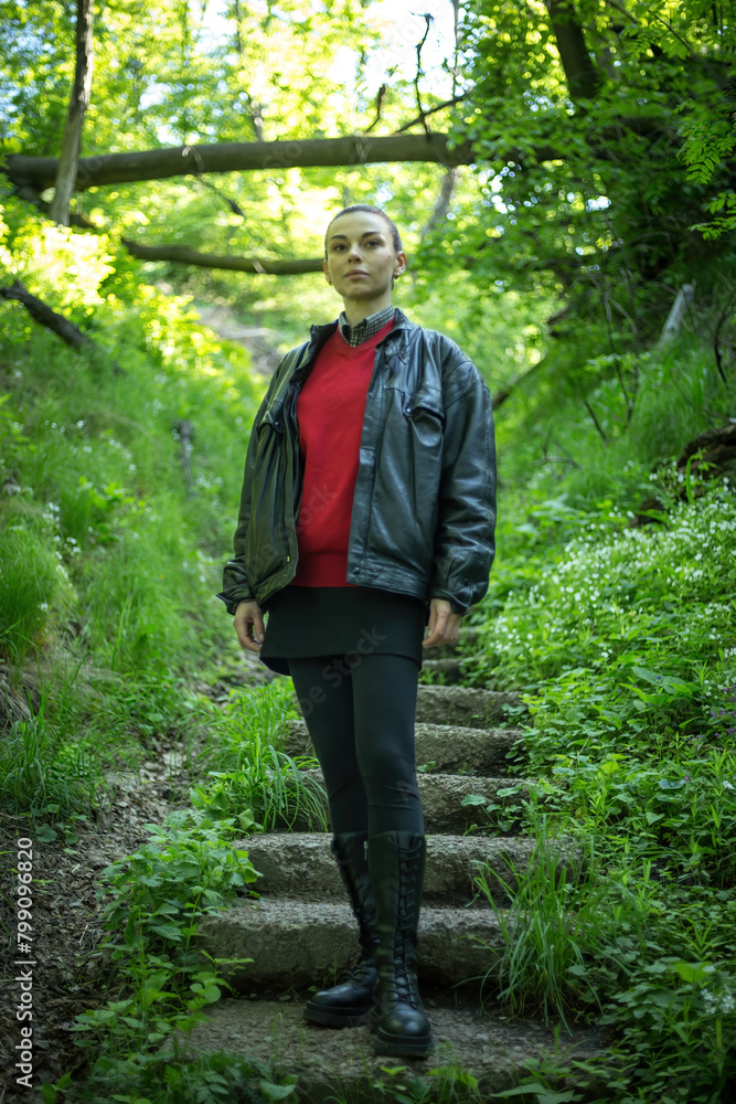 Girl in rubber boots posing in a spring forest, surrounded by blossoming trees and vibrant greenery, exuding the essence of nature's renewal. Girl in rubber boots posing in a spring forest, surrounded by blossoming trees and vibrant greenery, exuding the essence of nature's renewal.