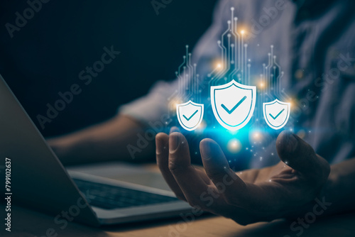 Blue Cybersecurity or Privacy Protection Concepts and Internet Security Systems. Cybersecurity Shield Icon and Circuit Line on Human Hand work with Laptop Computer in Vintage