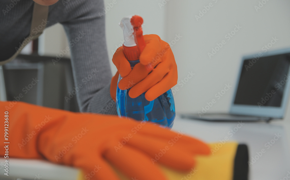 Woman cleaning table using rag and diffuser at home. Woman cleaning table using rag and diffuser at home.