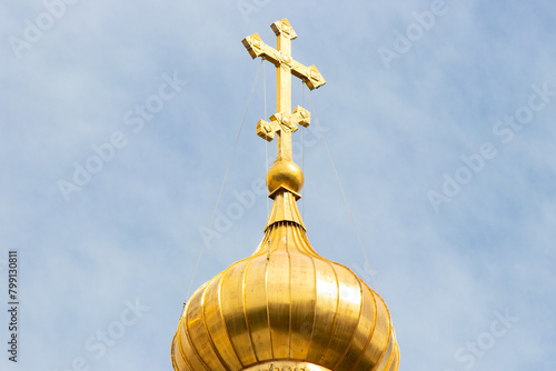 The golden dome and the cross of the Orthodox church against the blue sky and clouds. Church of St. Mary Magdalene, Jerusalem.