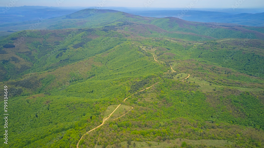 Early spring green mountains from above, panoramic view of hills and nature. Aerial photo taken from a drone.
